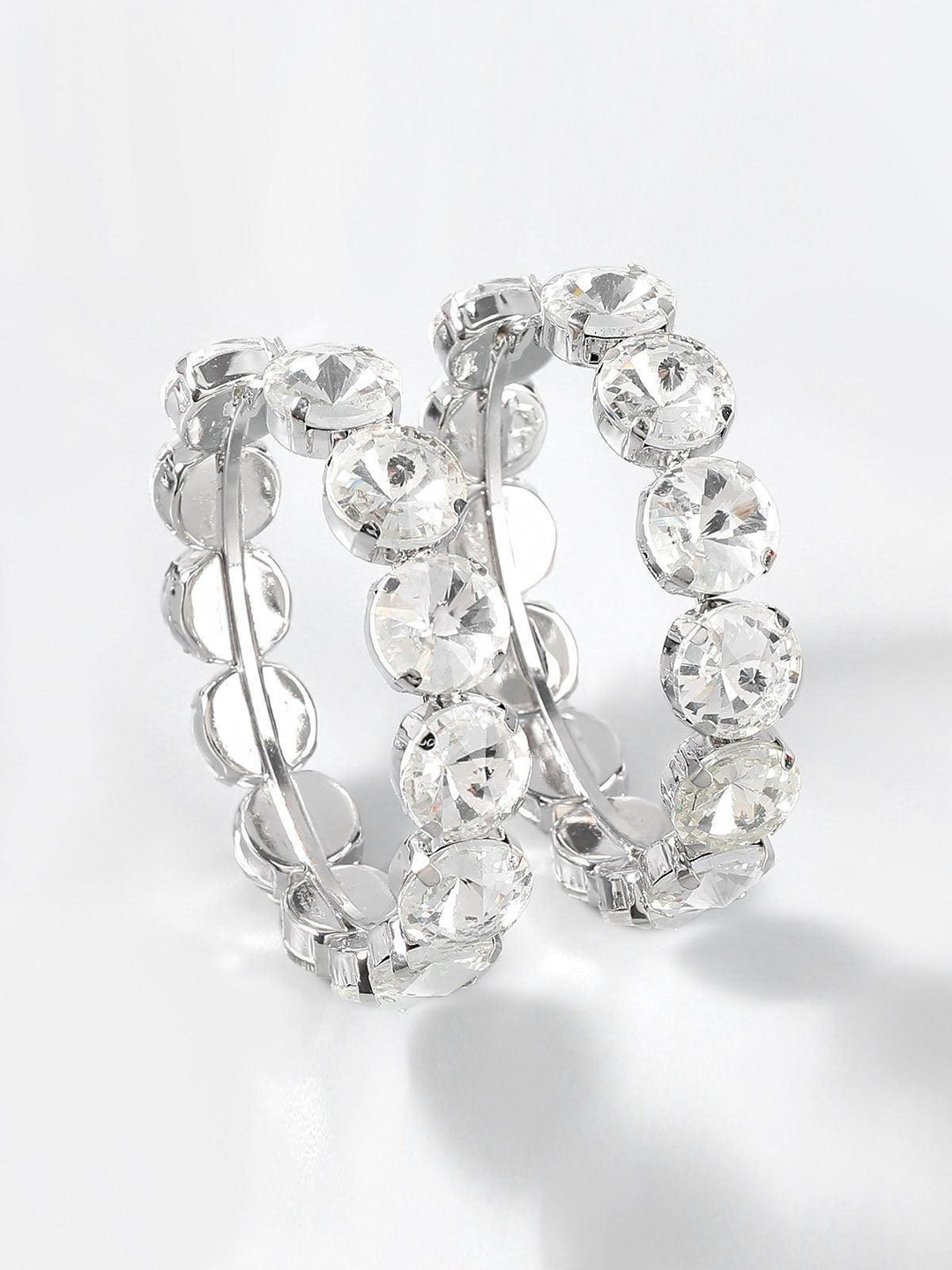 Aretes aro Auxana con piedras engastadas, diseño elegante, de tamaño medio y acabado brillante en plata.