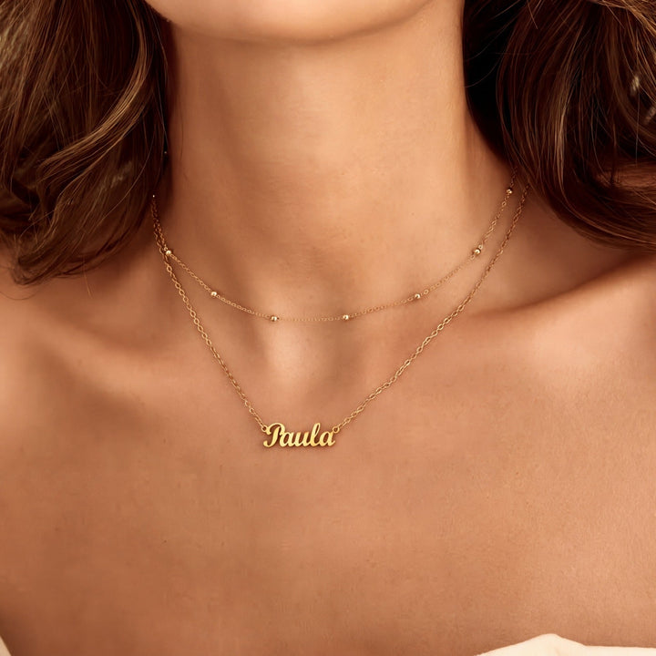 Collar de tenis personalizado con nombre en plata de la marca Auxana, con detalles elegantes y diseño ajustado para uso diario.