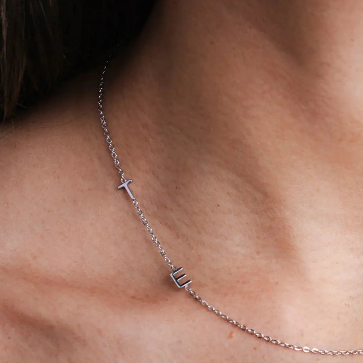 Collar personalizado con iniciales de Auxana, dorado y delicado, con colgante de letras en estilo elegante y moderno.
