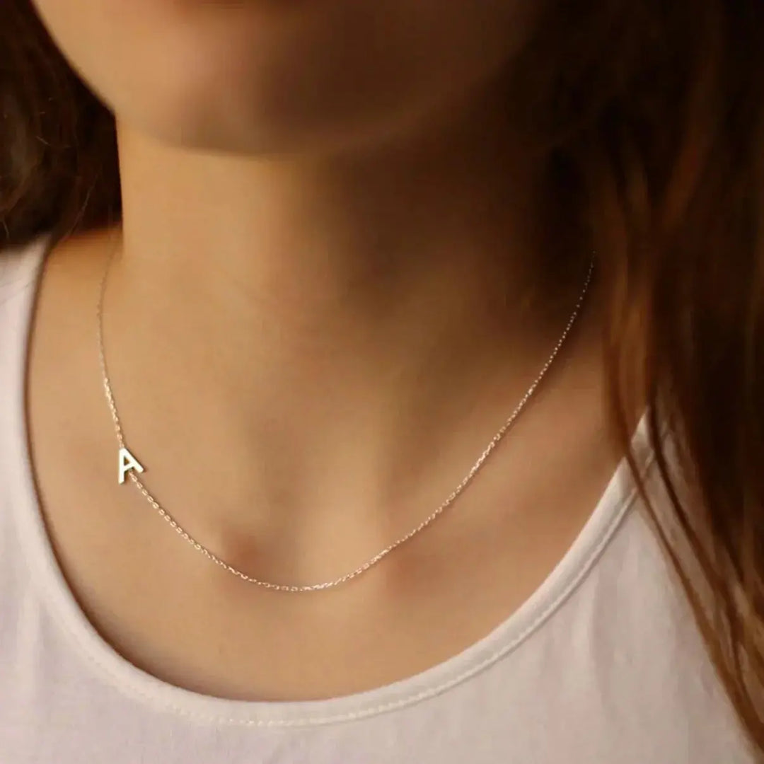 Collar con iniciales personalizadas de Auxana, con cadena delicada y letras grabadas, en plata brillante.