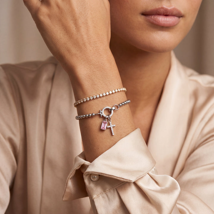 Pulsera de Auxana con dije de cruz y piedra natal, muestra la cadena y el colgante en detalle sobre fondo neutro.