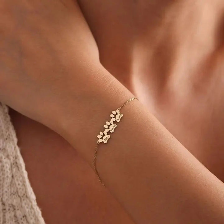Pulsera personalizada con huellas de Auxana, con charms en plata y detalles grabados, ideal para regalo sentimental.